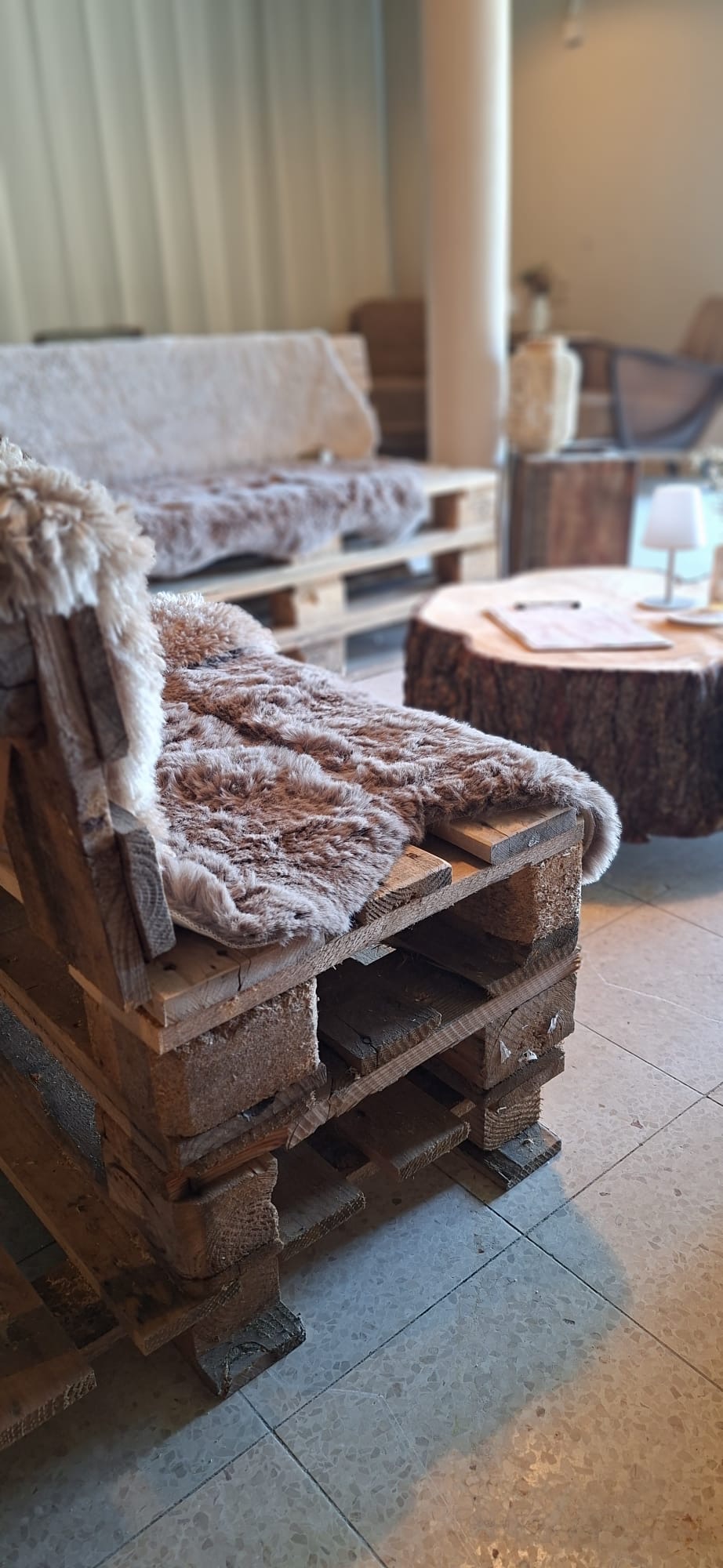 Palettensofa mit Fell und Baumstamm-Tisch
