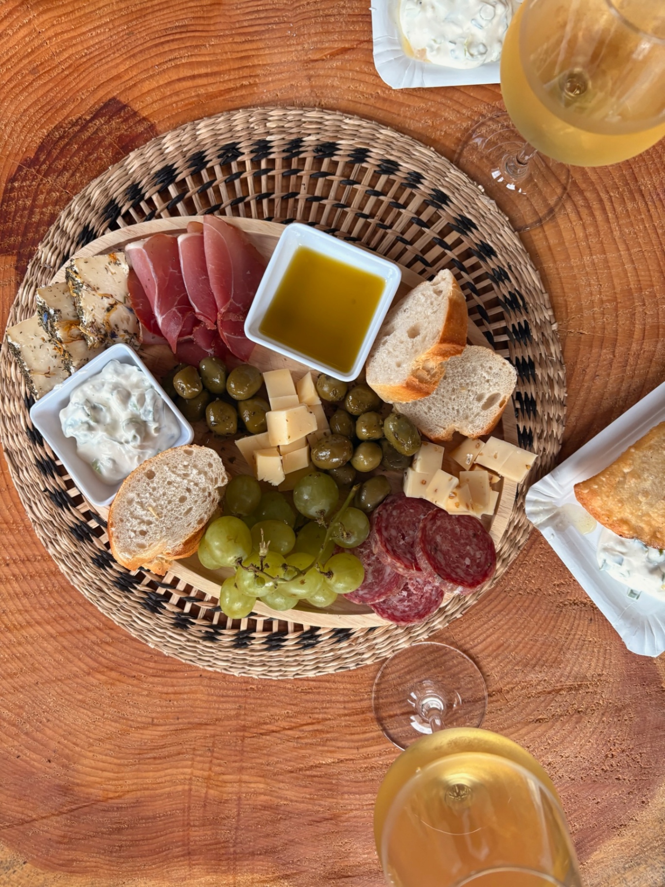 Snackteller von oben mit Trauben, Käse, Salami und Olivenöl